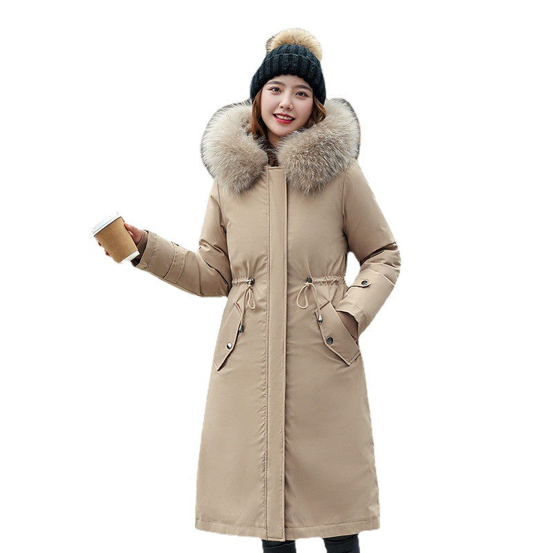Woman wearing a beige winter coat with a fur-lined hood on a white background