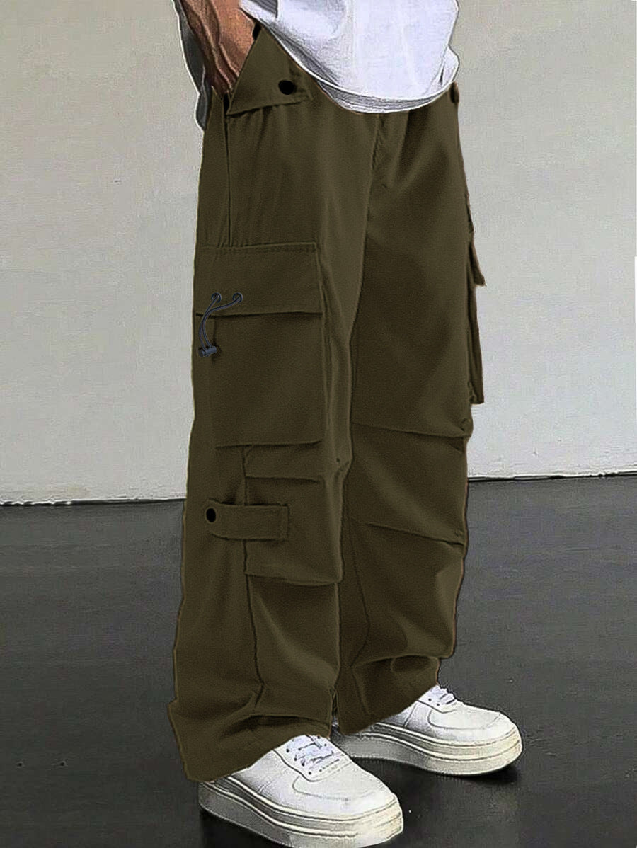 Person wearing olive green cargo pants with a plain background