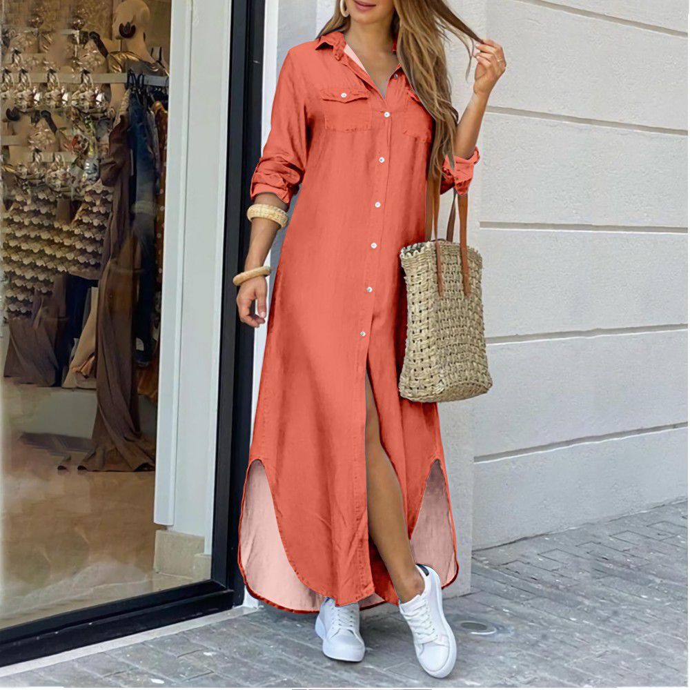 Woman wearing a long coral dress with a straw bag, standing outside a store.