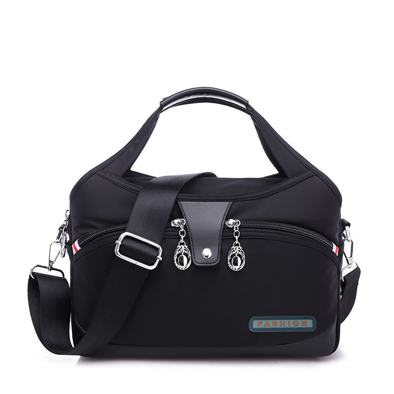 Black handbag with multiple zippers and a visible brand logo on a white background