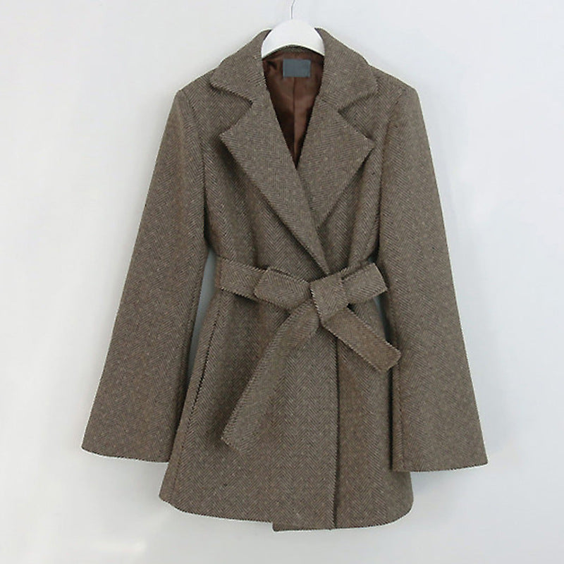 Brown coat with a belt on a white hanger against a white background