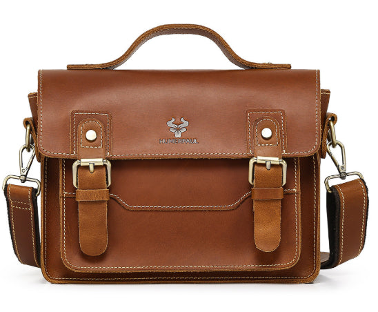 A brown leather messenger bag with a top handle, buckle straps, and a silver-toned logo on the front flap, shown against a plain white background.