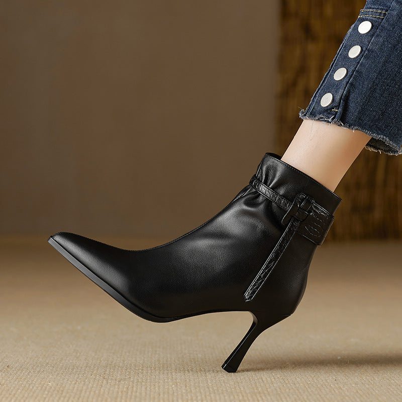 Black leather ankle boot with a high heel on a neutral background