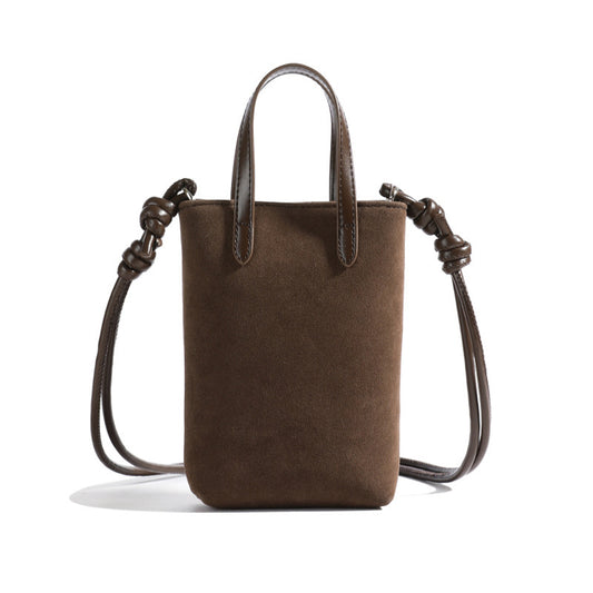 Brown leather handbag with braided handles on a white background
