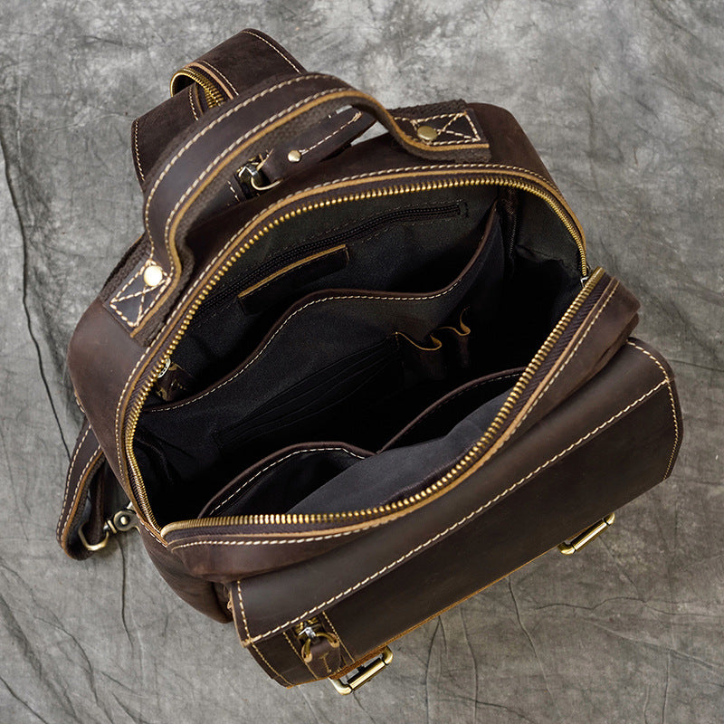Brown leather backpack with gold zippers on a gray background