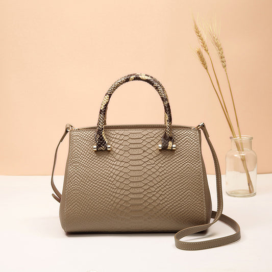 Beige handbag with snake skin pattern on a beige background