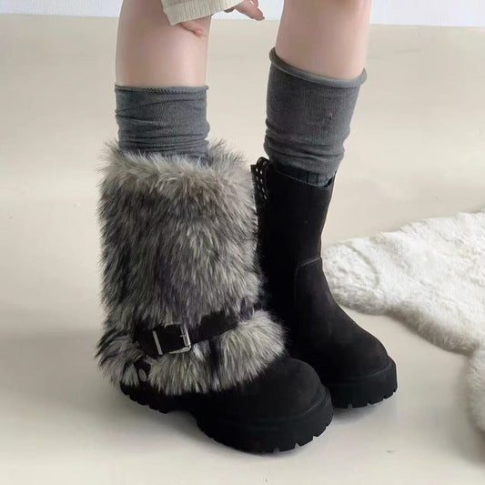 Black boots with fur trim worn by a person on a light background