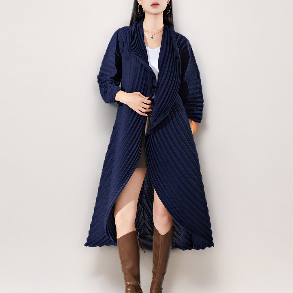 Woman wearing a long navy blue coat with a white background