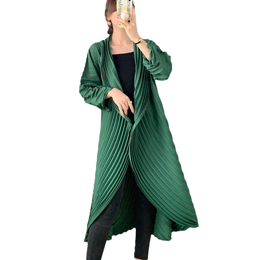 Green pleated dress over a black outfit on a white background