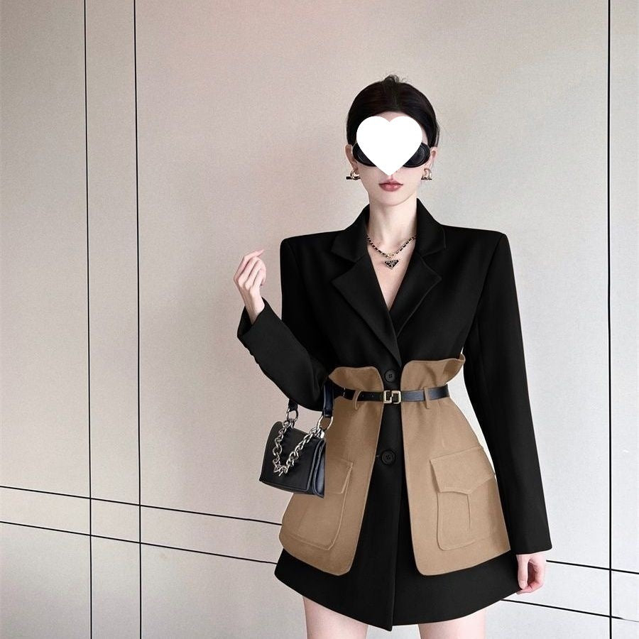 Woman wearing a black and beige two-tone coat with a plain background