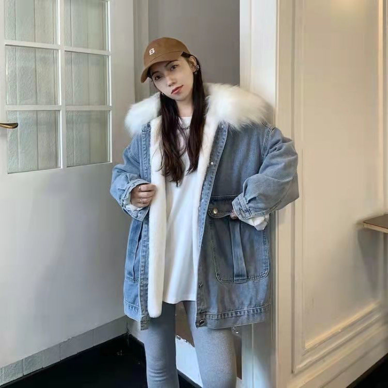 Person wearing a denim coat with fur trim in a room.