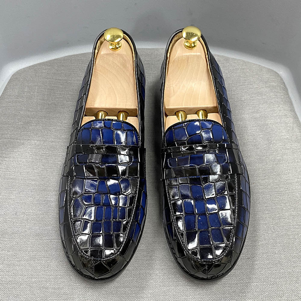 Pair of blue and silver mosaic loafers on a gray surface