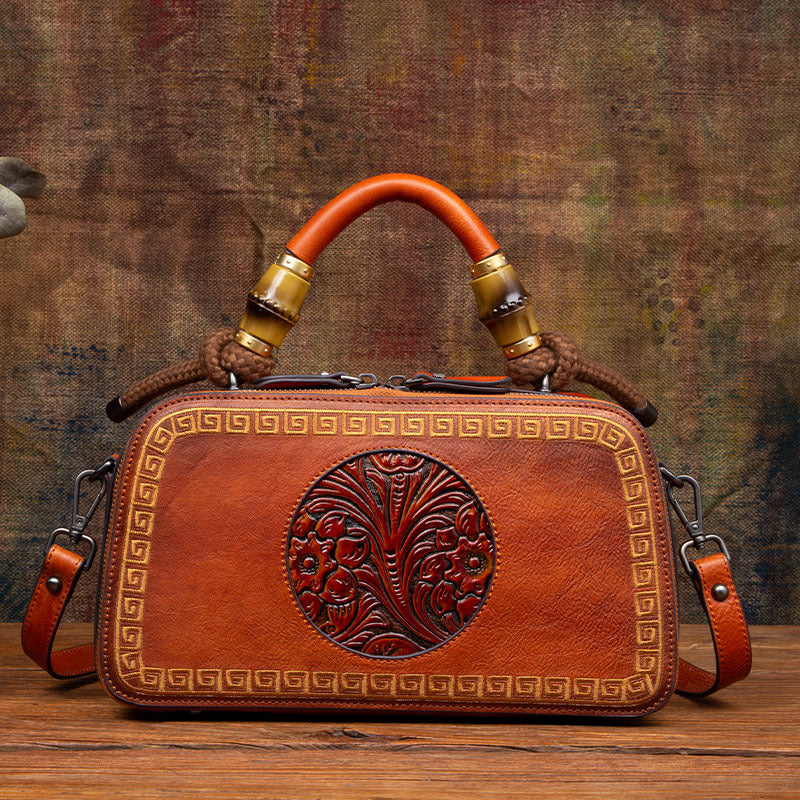 Brown leather handbag with decorative patterns on a wooden surface and textured brown background