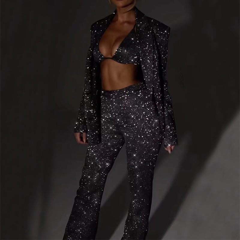 Person wearing a sparkling black outfit on a dark background