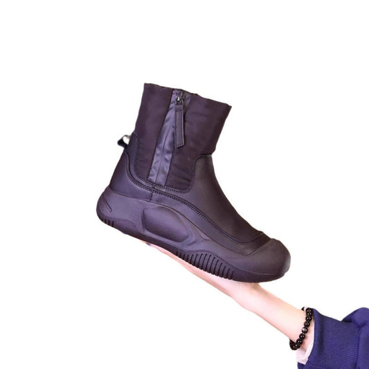 Purple ankle boot held by a hand on a white background