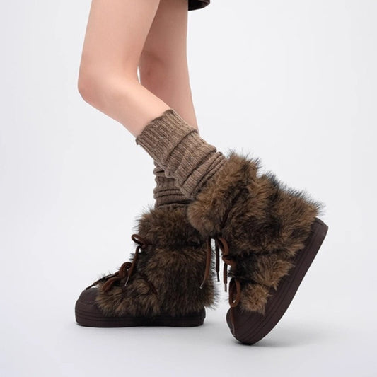 Brown furry shoes with a person wearing them on a light gray background
