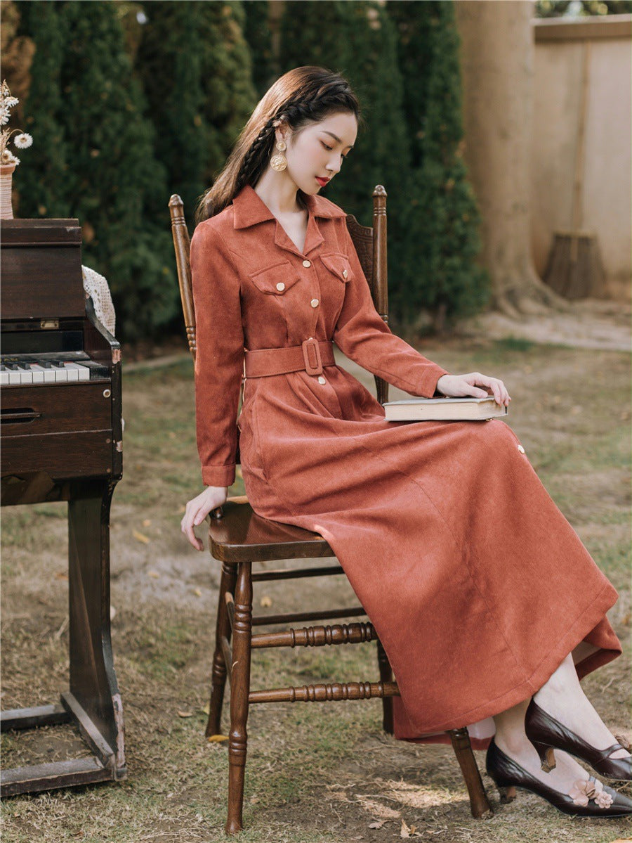Woman in a long coat sitting on a chair with a book, next to an old piano outdoors. by millivan