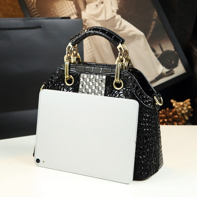 Black and white handbag with gold accents on a blurred background