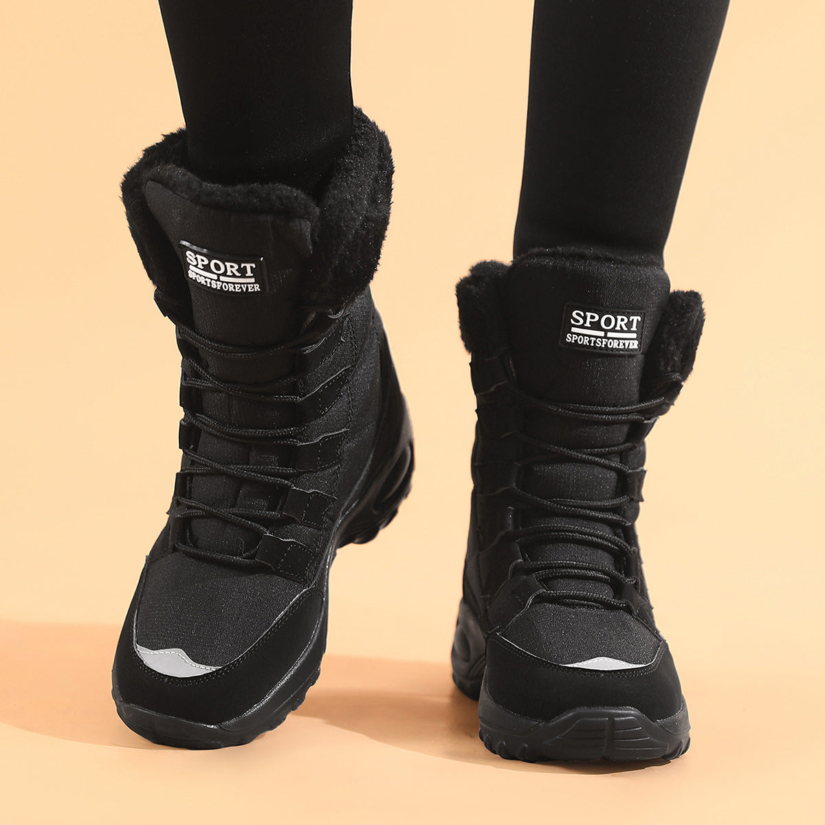 Black winter boots with fur lining on a beige background